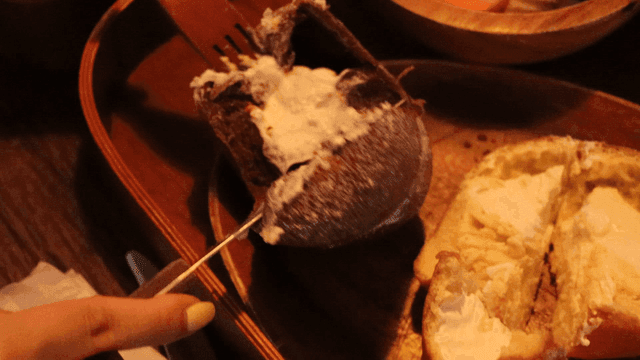 A person slicing a cream-filled bread