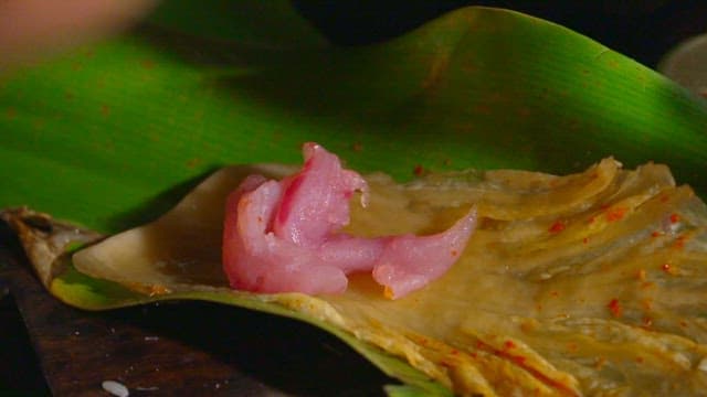 바나나 잎과 김치 위에 참치를 플레이팅 하는 모습