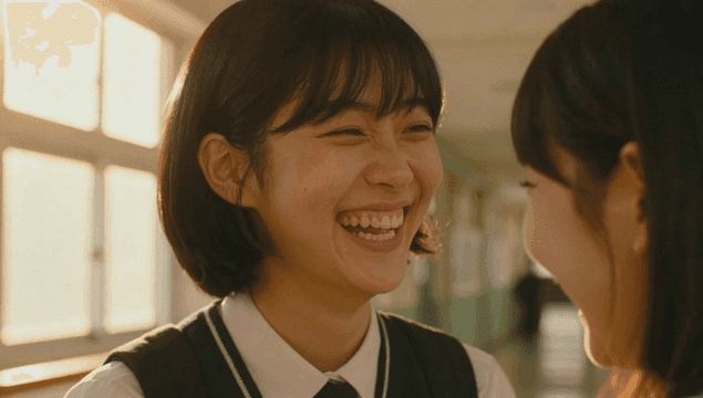 Two schoolgirls smiling at each other in the school hallway
