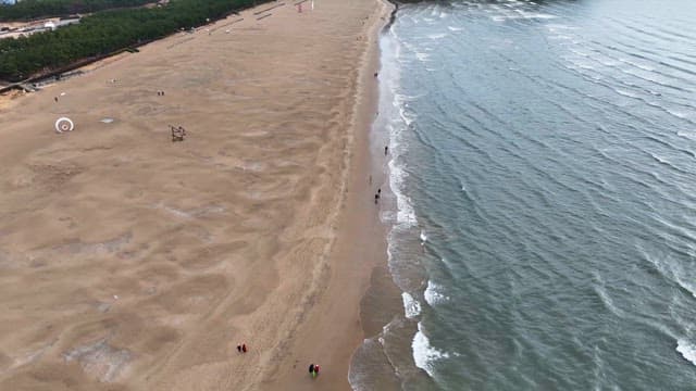 잔잔한 파도가 있는 넓은 모래 해변