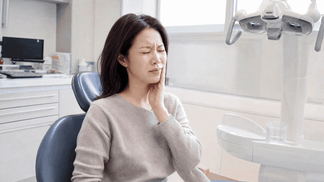Female patient suffering from toothache at dental clinic