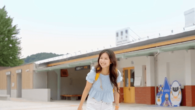 기차역에서 웃으며 손을 흔드는 젊은 여성