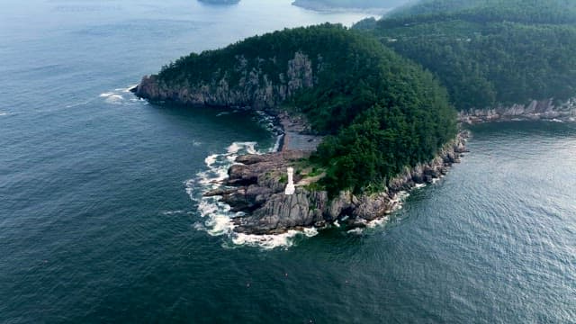 Lighthouse and Seascape at the Edge of a Forested Cliff