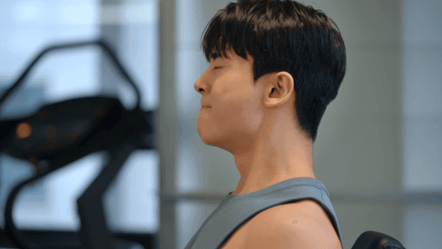 집중하며 헬스장에서 운동하는 남성