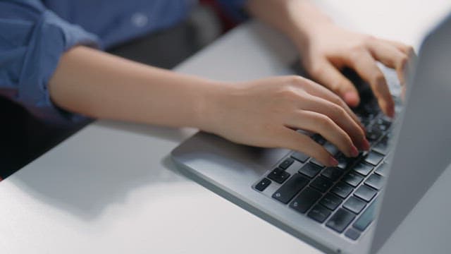 노트북 키보드를 타이핑하는 손