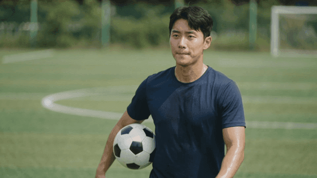 Man holding soccer ball on soccer field