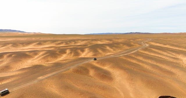 Vehicle traveling through a vast desert