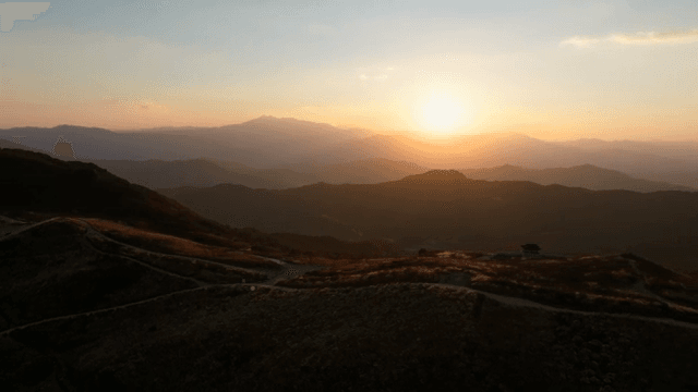 구불구불한 산 풍경 위의 일몰