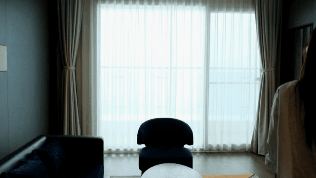 Back view of woman entering bright hotel room