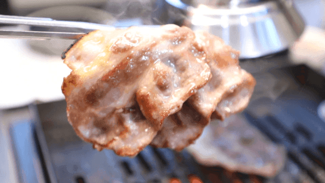 Chopsticks on hot grill with pork belly
