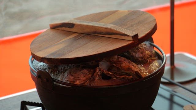 Fresh oysters prepared in a pot on a gas stove in tent