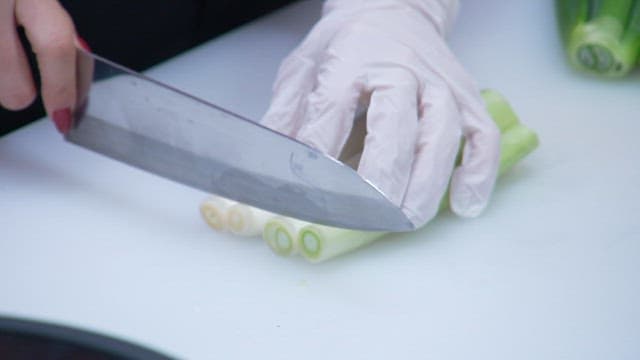 Preparing green onion with precision knife skills on a cutting board