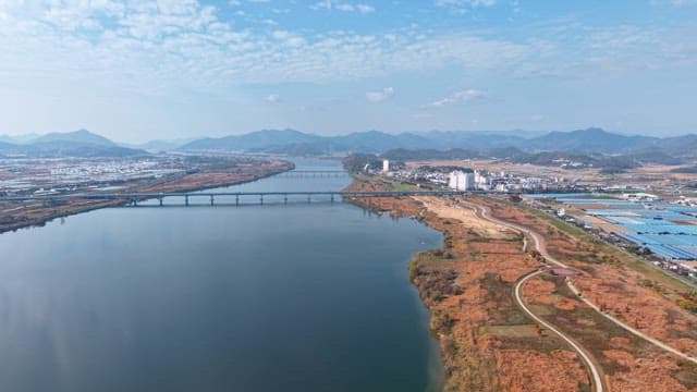 Serene river flowing beside farmland and mountains