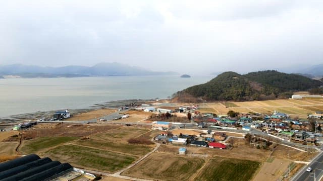 Coastal village with agricultural fields on a sleet winter day