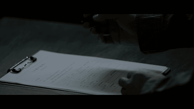 어두운 방에서 문서에 글을 쓰는 사람