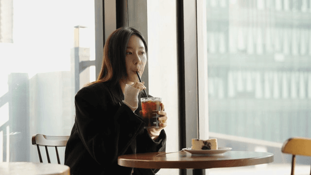 Woman enjoying iced coffee in a cafe
