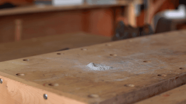 나무 테이블에서 먼지를 쓸어내는 모습