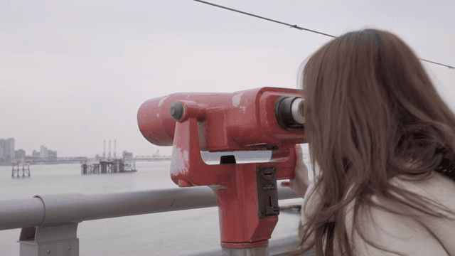 여성이 망원경으로 스카이라인을 관찰하는 모습