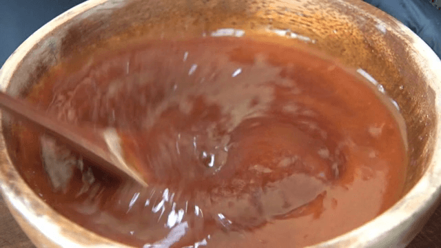 나무 그릇에서 빨간 소스 섞기