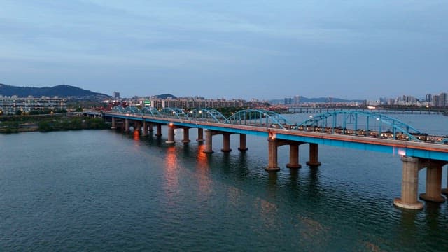 도시 스카이라인이 보이는 강 위의 다리