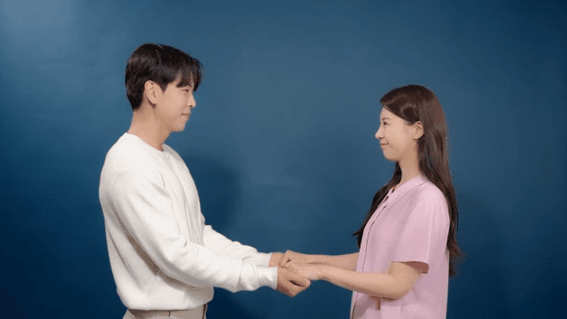 실내에서 손을 마주 잡고 웃고 있는 커플