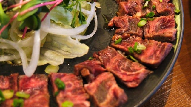 Freshly prepared vegetables and beef tataki on a plate