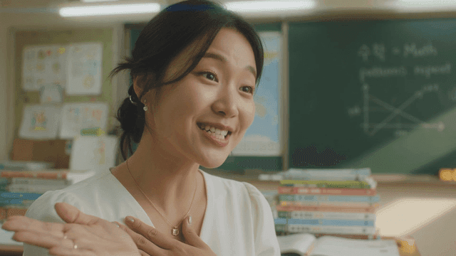 Elementary school teacher teaching with smile in classroom