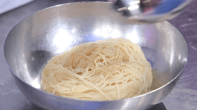 Handmade soy sauce being poured over wheat noodles