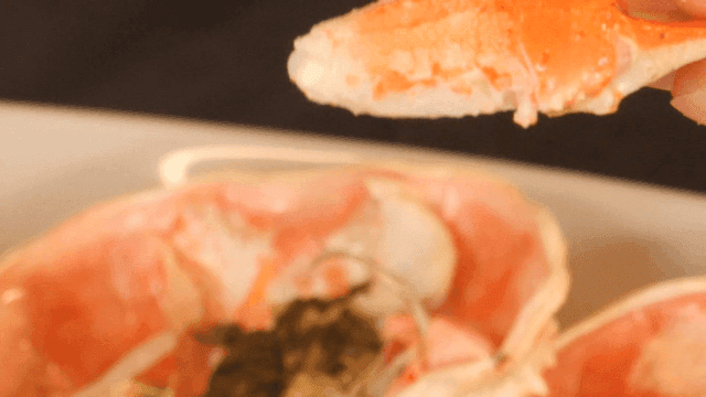 손으로 게 집게를 까는 모습