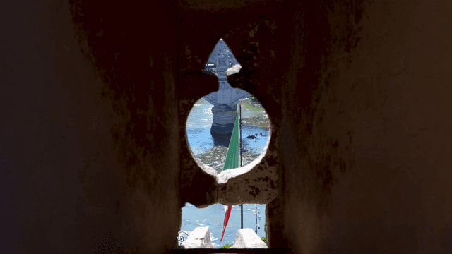 Bridge and Italian flag seen through stone window