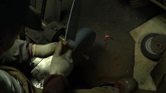 Worker sharpening a knife in a workshop