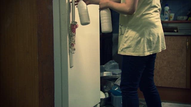 Putting away a Bottle of Makgeolli in a Kitchen Fridge