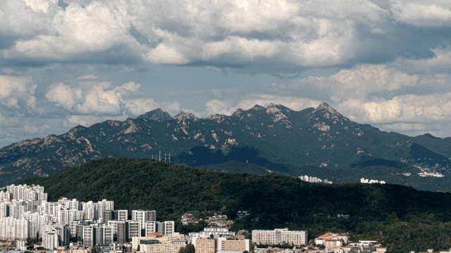 고층 아파트 뒤로 높은 산