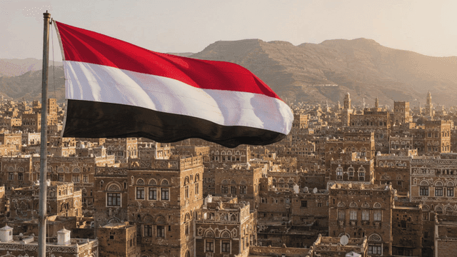 Panoramic view of city with Yemeni flag fluttering in wind