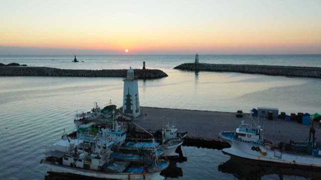 Fishing boats docked in marina at sunset