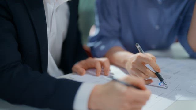 People discussing documents at a table