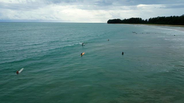 Surfers catching waves on a cloudy day