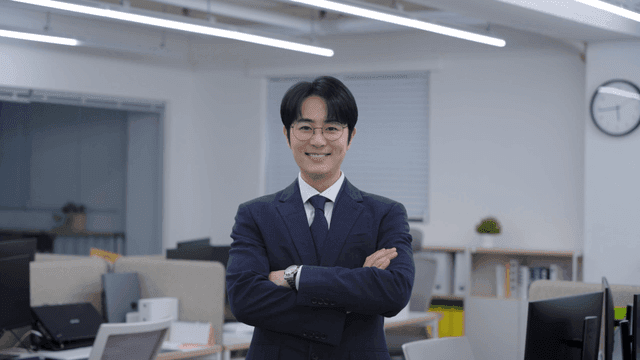 An office worker smiling with arms crossed in the office