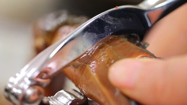 간장게장의 게 다리를 집게로 자르는 모습