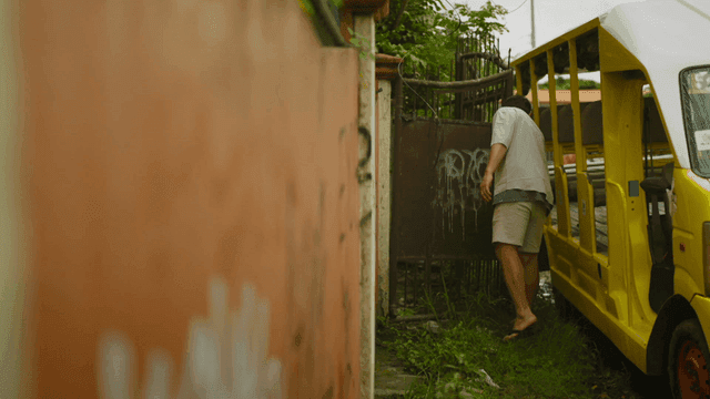 Back view of person walking next to yellow vehicle