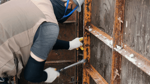 금속 구조물에 도구를 사용하는 작업자