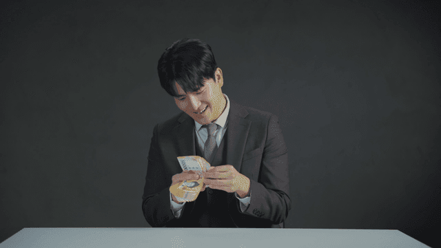 Man in a suit counting money with a satisfied expression