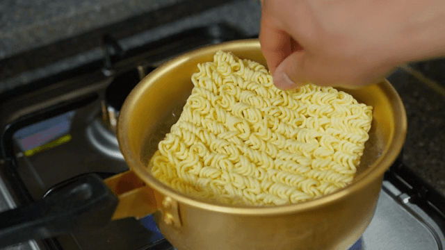 Adding noodles to boiling pot