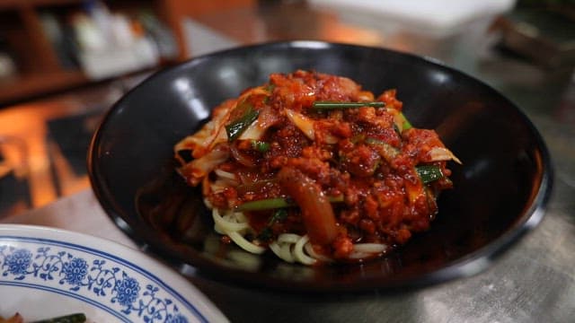 매콤한 볶음 소스가 올라간 국수 요리