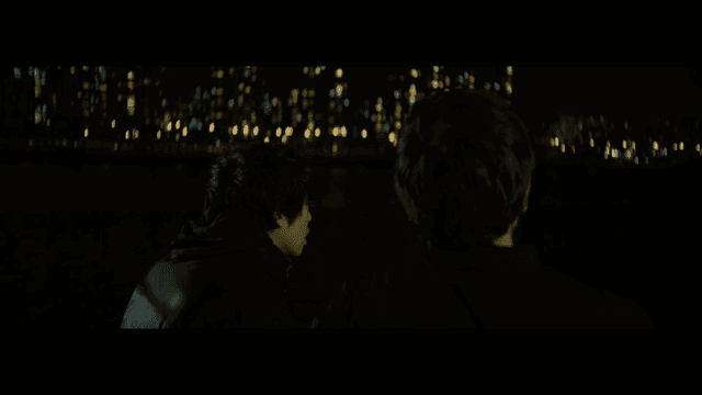 Two people looking at city lights at night