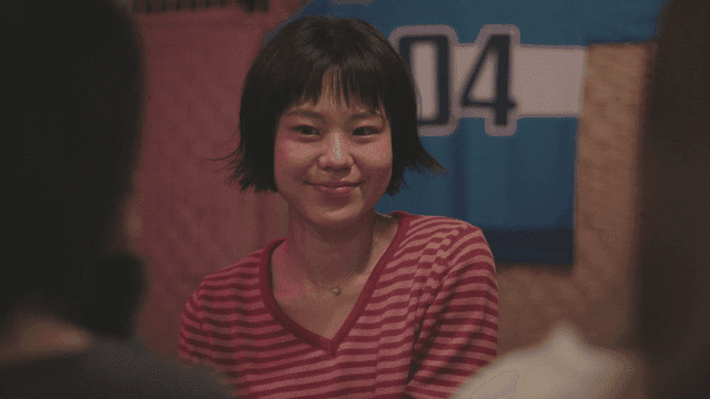 Woman in a striped shirt talking indoors