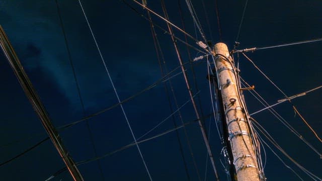 Telephone pole with wires against a night sky