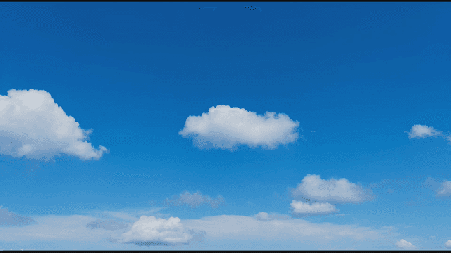 Clear blue sky with fluffy clouds