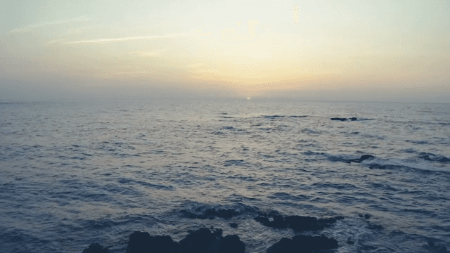 바위가 있는 고요한 바다의 일몰