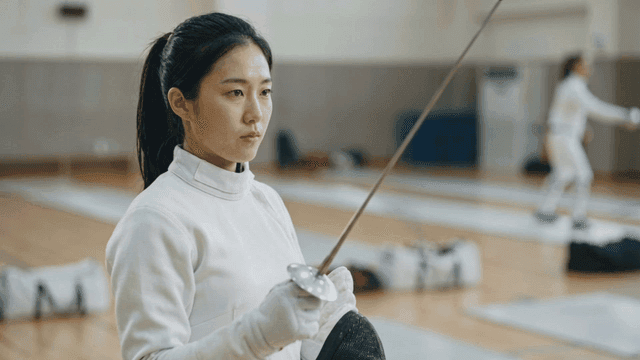 Fencer practicing fencing in gym